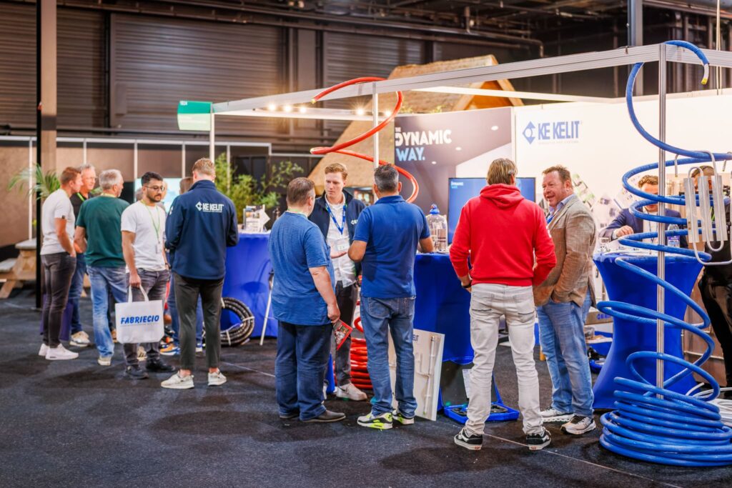 Bezoekers in gesprek bij een stand met kunststof leidingsystemen