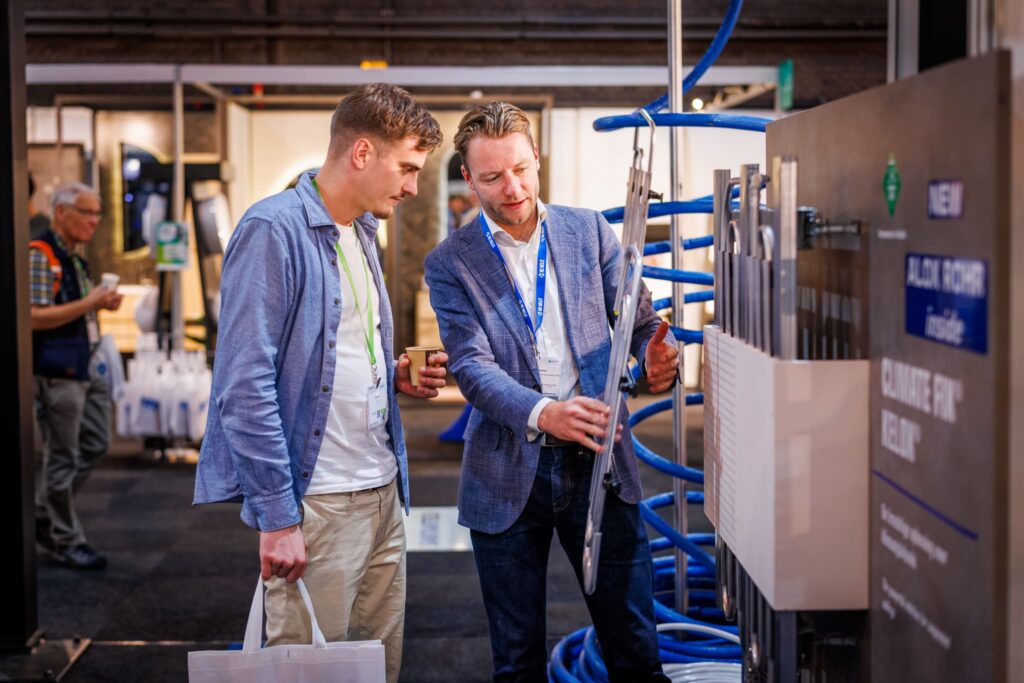 Standhouder licht een leidingsysteem toe aan een bezoeker