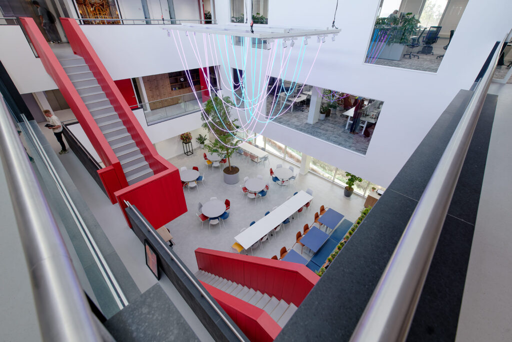 Blik van bovenaf in het atrium met de rode trappen